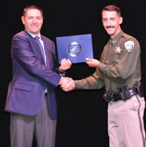 Attorney General Knudsen presents diploma to graduate of Law Enforcement Officer Basic Course 187.